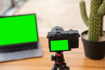 Camera on tripod and laptop with green screen chromakey