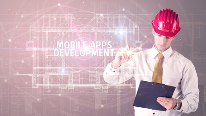 Handsome architect with helmet drawing MOBILE APPS DEVELOPMENT inscription, new technology concept