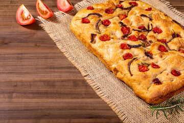 Traditional Italian Focaccia with cherry tomatoes, black olives and rosemary.