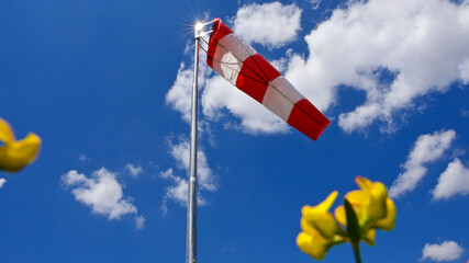Windsock. Windsock flag. Wind direction indicator. Wind intensity. Windsock in front of blue sky,...