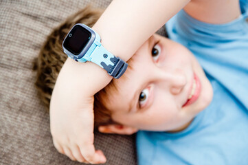 Boy with a smart watch. Children and modern technology. Player on hand.