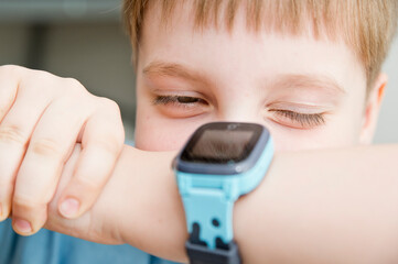 Boy with a smart watch. Children and modern technology. Player on hand.