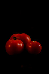 red tomato on black background