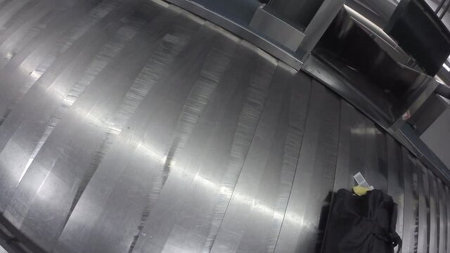 Luggage coming down the chute onto an airport carousel