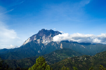Mount Kinabalu and clouds drifting seen from Pekan Nabalu near Kinabalu National Park, Sabah...