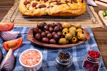 Traditional Italian Focaccia with pepperoni, cherry tomatoes, black olives, rosemary ando onion - homemade flat bread focaccia