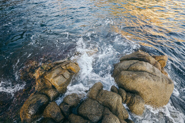 A close up of a rock next to water
