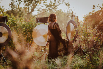 Young woman in black dress posing with Hong in the forest. Sunset.