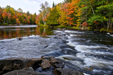 The river rapid in a public park with autumn leaf color.