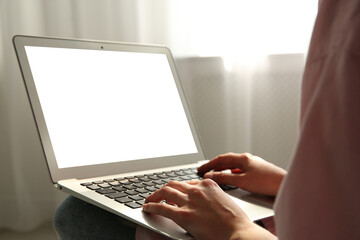 Woman working with modern laptop indoors, closeup