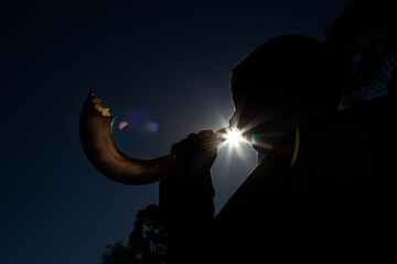 
Man blowing Shofar, horn used as a musical instrument by Jews