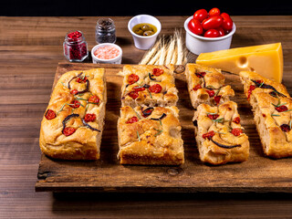 Traditional Italian Focaccia with cherry tomatoes, black olives and rosemary