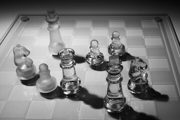 International chess day concept. Glass chess with shadows on checkerboard