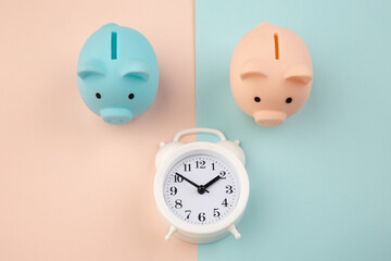 Time to invest. White clock and piggy bank on pink blue pastel background.