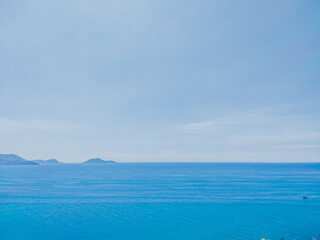 Deep blue ocean panorama with boat in a turquoise tropical sea under clear sky background. Tropical holiday paradise concept, the end of quarantine Covid 19 isolation - beginning of normal life again