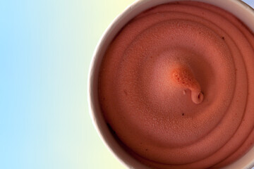 Top view close up chocolate textured ice cream in round cup with blue copy space