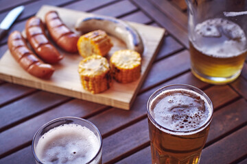 Glasses, beers on a table with a sausage board