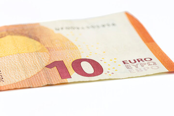 Obraz premium Macro shot of a European Union banknote of 10 EUR, close-up of the number ten, isolated on a white background, selective focus.