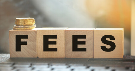 Coin stack and wooden blocks with the fee text. Fee Finance and Money concept