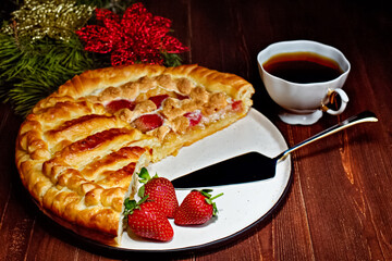 Big round pie. Traditional home baking. The cake is on a white plate on a wooden table. Very tasty and fragrant.