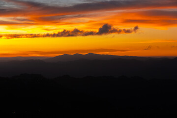 Sunset colours in the sky above silhouetted mountains in the city of Aizawl in Mizoram.