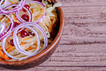SauPickled cabbage in bowl with wooden spoon and seasoning.  Vegetarian clean food. Paleo diet. Healthy eating concept . With carrot in a plate. Top view. Copy space.
