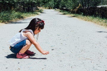 Black haired girl squatting in the field