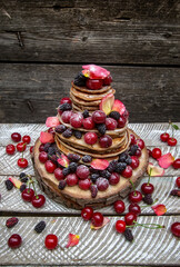 homemade pancakes with cherry and mulberry on a wooden cut