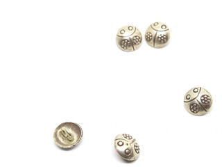 Silver ladybug buttons on white background.