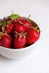 strawberries in a bowl on a white background