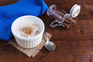 Creamy rice pudding and cinnamon on a wooden base. Pastry concept.