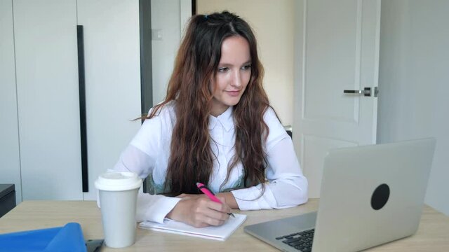 Pretty girl employee is skyping in a room talking looking at laptop screen gesturing at work enjoying modern technology and communication. People and internet concepts. 4k