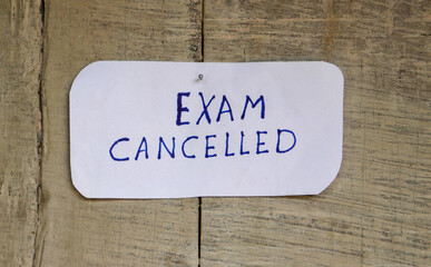 Exam Cancelled Written on White Note Pinned on Wood