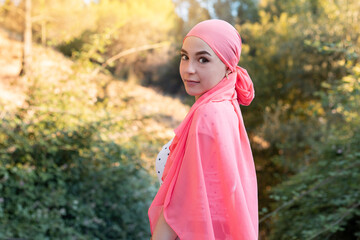 Woman with cancer wearing a pink scarf looking fighter