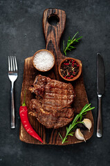 Grilled beef steak with spices on a stone background