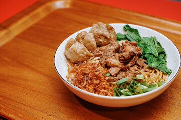 Chicken noodles with some beef meatballs. pieces of mustard leaf