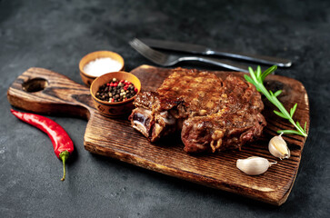 Grilled beef steak with spices on a stone background