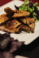 Chicken tabaka with greens on a color background.