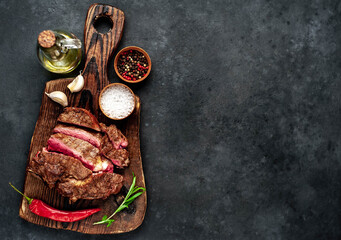 Grilled beef steak with spices on a stone background with copy space for your text.