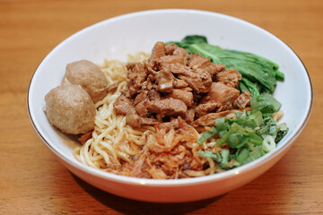 Chicken noodles with some beef meatballs. pieces of mustard leaf