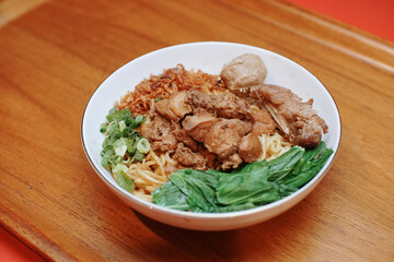 Chicken noodles with some beef meatballs. pieces of mustard leaf. rib meat