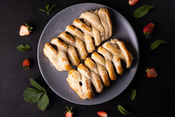 Chocolate puff pastry. Home baked dark chocolate sweet pie on black background with copy space