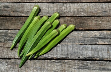 Raw Lady Finger or Okra Vegetable Isolated on Wooden Background with Copy Space for Texts Writing