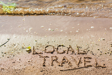 Local travel. The inscription on the sand by the river and waves. Summer tourism