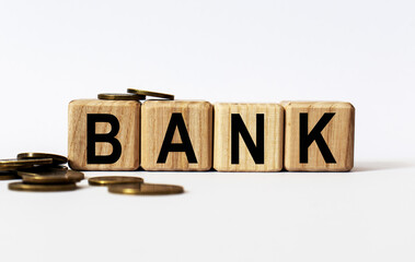 wooden cubes and BANK, coins, the concept of taxation, increase taxes and fees