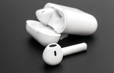 Bluetooth headphones with box on black background.