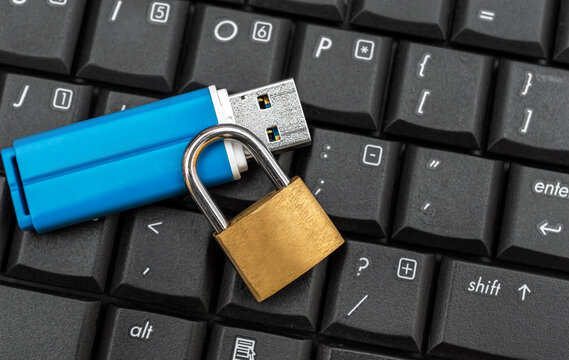 Flash drive with padlock on the laptop keyboard.