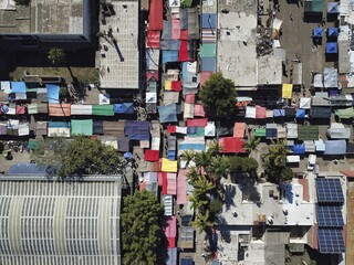 Sky drone view high angle shot of an open-air Sunday flea market in a poor city