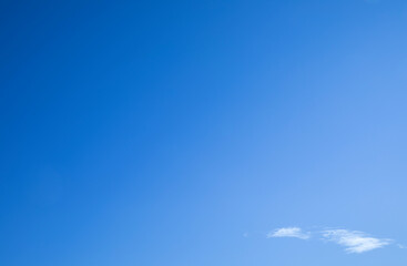 Clean blue sky with a cloud at left