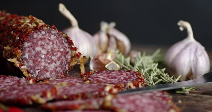 Slices of salami with garlic and rosemary slowly rotate.